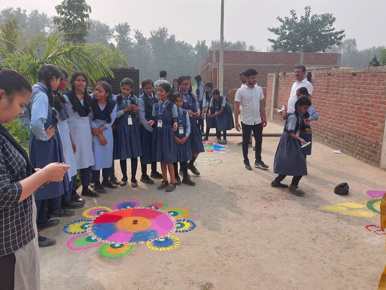 Students gathered around rangoli design